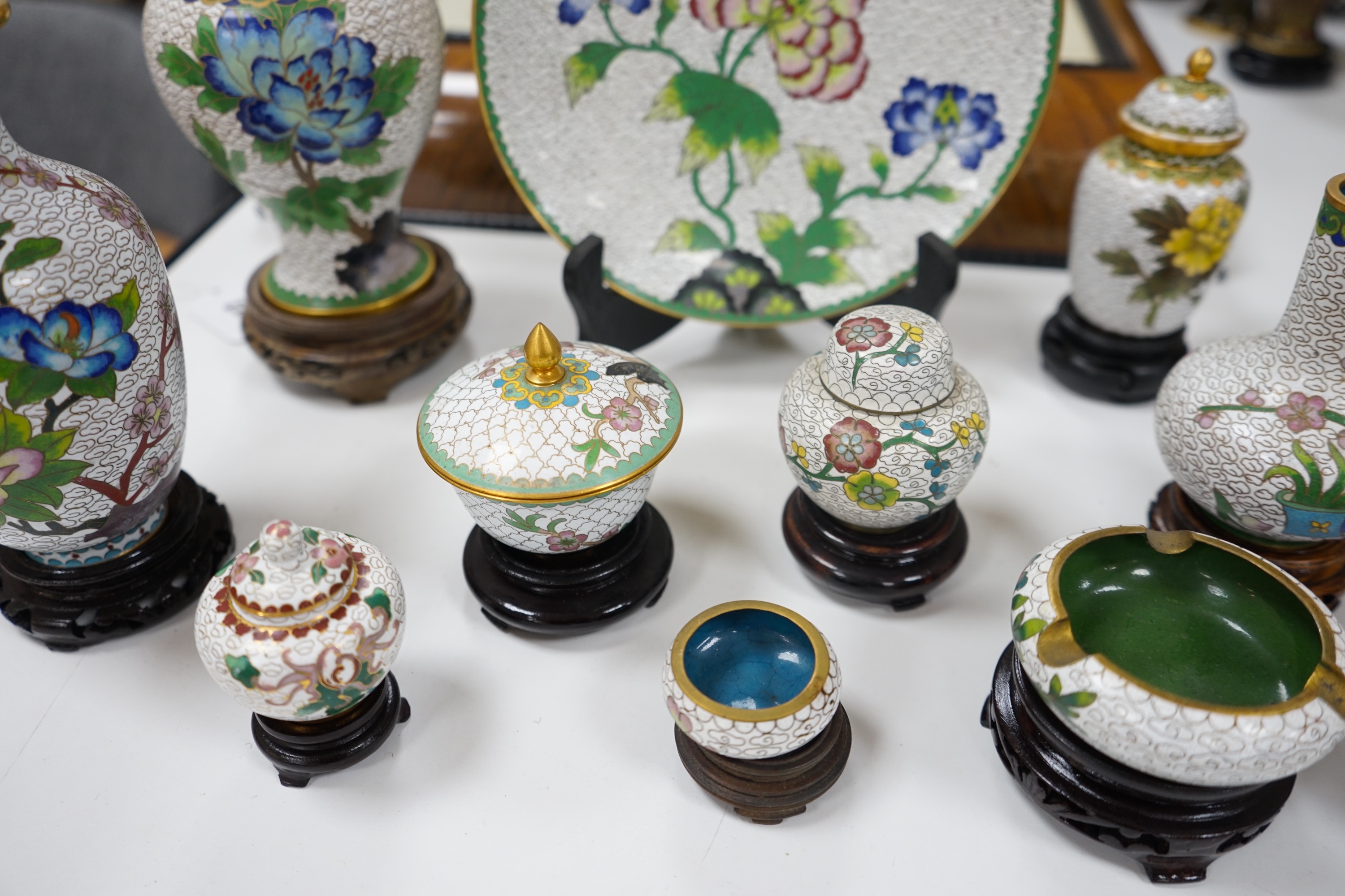 A collection of Chinese cloisonné enamel vases, pots etc., all worked on a white background in floral designs, plate, 20cm diameter. Condition - good